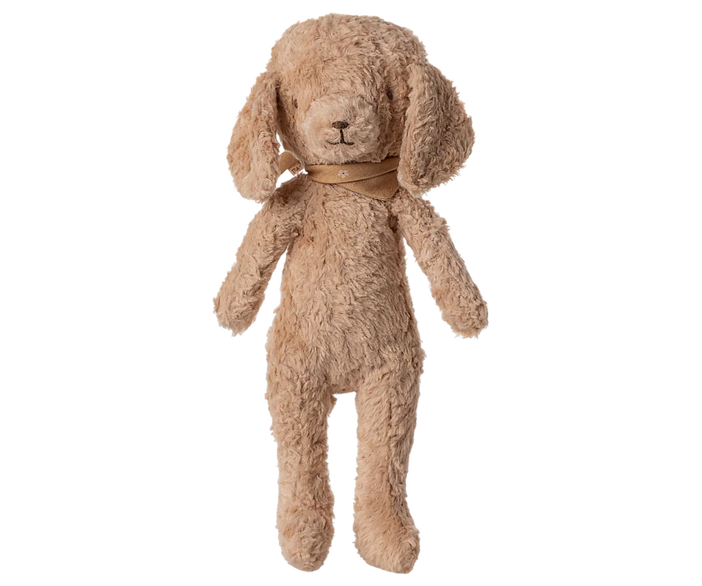 The Maileg Poodle Dog, Vintage Plush in Dusty Powder stands upright against a plain white background. This soft puppy toy features floppy ears, dusty powder-colored fur, and a brown scarf around its neck.