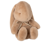 The Maileg Plush Bunny, Medium - Cream Peach, is a soft light brown toy with long floppy ears, round limbs, and a small bow around its neck, shown sitting upright against a plain white background.