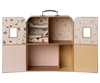 The Maileg Fully Furnished Christmas Suitcasa with Royal Twins is a decorative cardboard suitcase with a handle, featuring four pastel-lined compartments for Maileg mice and shelves displaying doll-sized bedding with cute animal designs.
