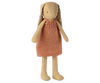 The Maileg Bunny, Size 2 in Cream Yellow, wears a sleeveless orange knitted dress and has long ears lined with a floral pattern. This soft linen doll stands upright against a plain white background.