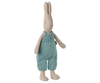 The Maileg Rabbit, Size 1 - Classic, wears light blue knitted overalls and stands upright—crafted from natural fabrics, it's ideal for a miniature dollhouse. Expected arrival: 02/15/26.