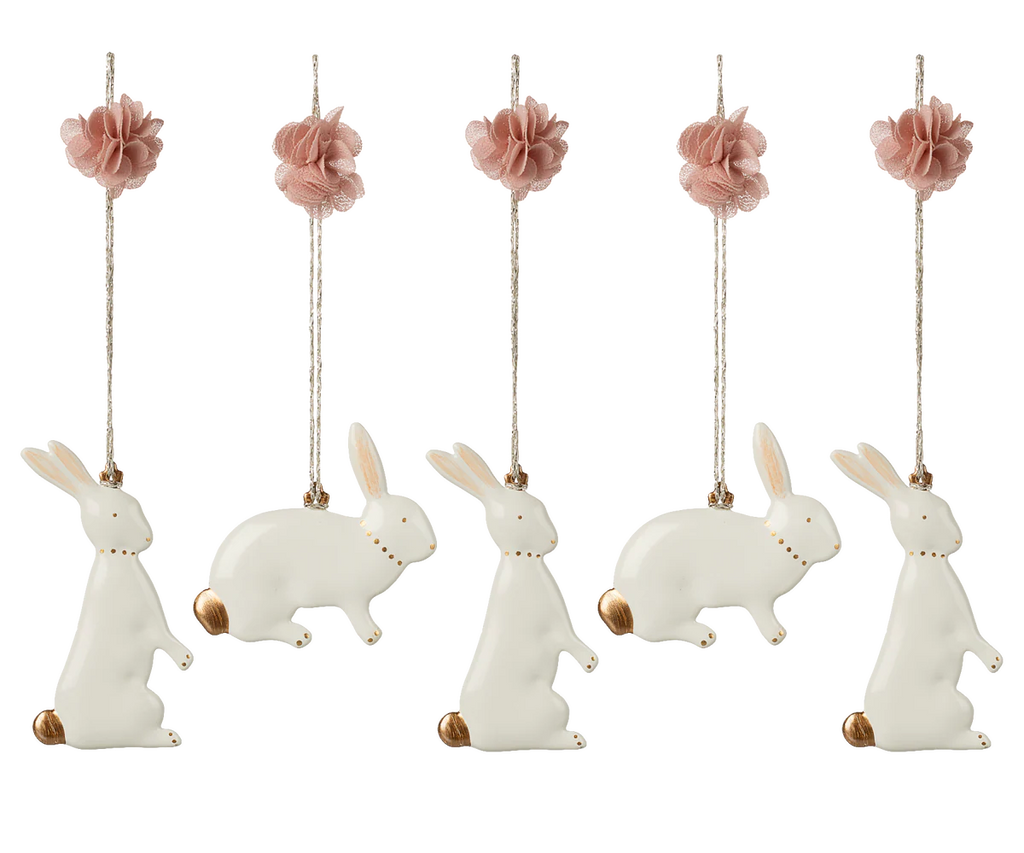 The Maileg Metal Ornament Set - Easter Bunny includes five charming bunny ornaments with gold tails and collars, pink fabric flowers, and hanging strings—perfect as a festive Easter decoration.