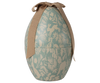 The Maileg Easter Egg, Medium - Dusty Blue, is a light blue metal egg box with beige floral and animal patterns featuring bunnies and birds, finished with a beige ribbon bow.