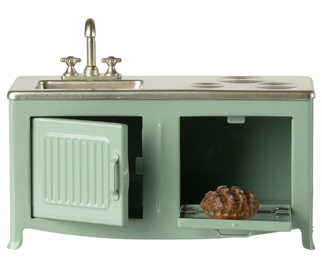 The Maileg Kitchen, Mouse - Mint (expected 02/15/26) is a miniature green kitchen set with a metal sink, faucet, stove burners, and an oven door that opens to reveal a tiny pie inside.