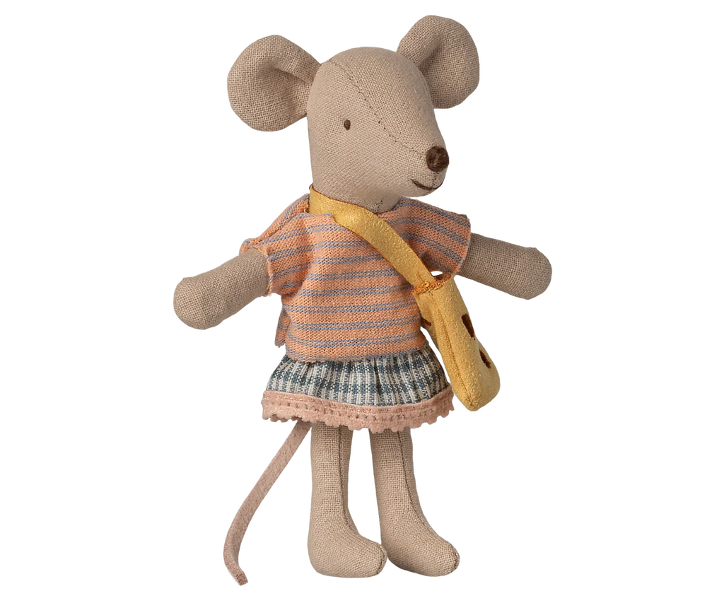 The Maileg Little Sister Mouse with Bag, wearing a striped orange top, plaid skirt, and yellow cheese bag, stands upright with arms outstretched against a white background. Expected arrival by 06/15/26.