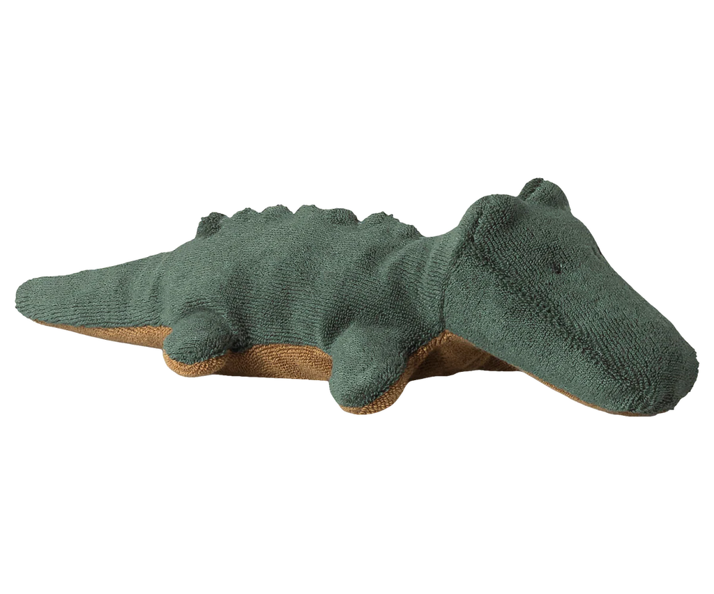The Maileg Crocodile, Mini - Forest Green is a plush toy with green textured fabric on top, brown underside, and simple embroidered eyes, shown lying on a white background. Expected arrival by 06/15/26.