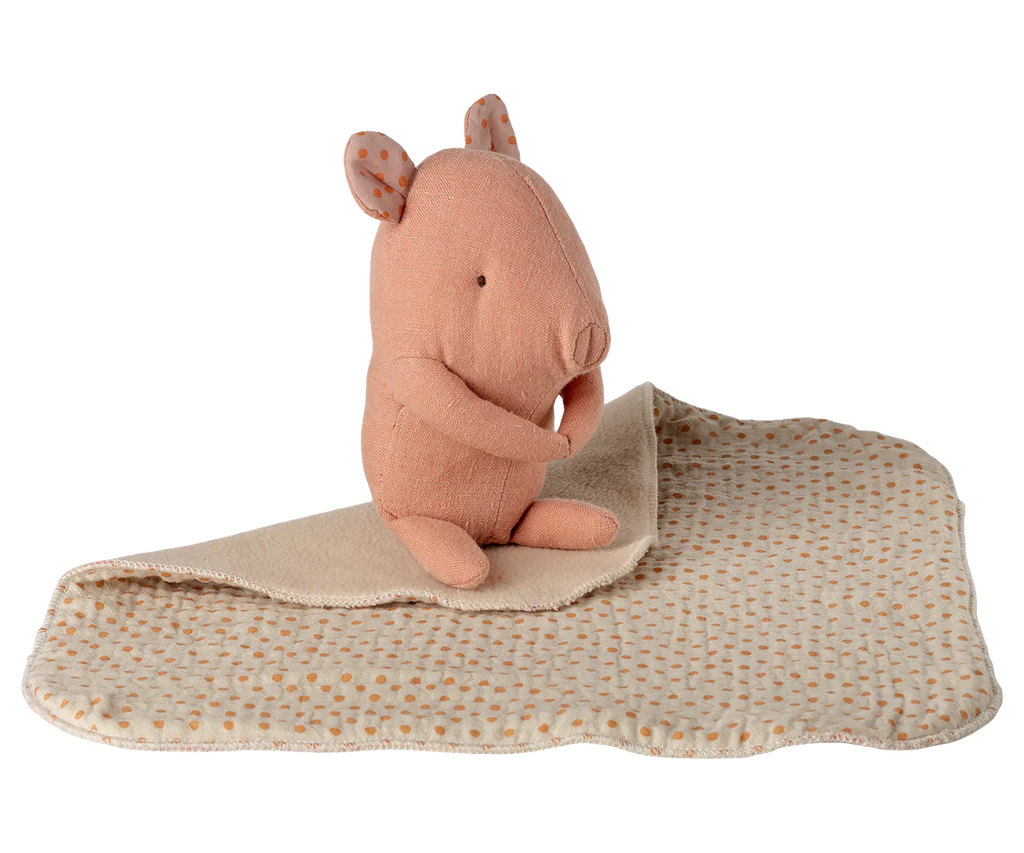 The Maileg Lullaby Friends, Pig, Mini - Rose is a soft toy shaped like a pink pig, resting on a cream-colored dotted cuddle cloth with stitched details—an adorable newborn gift.