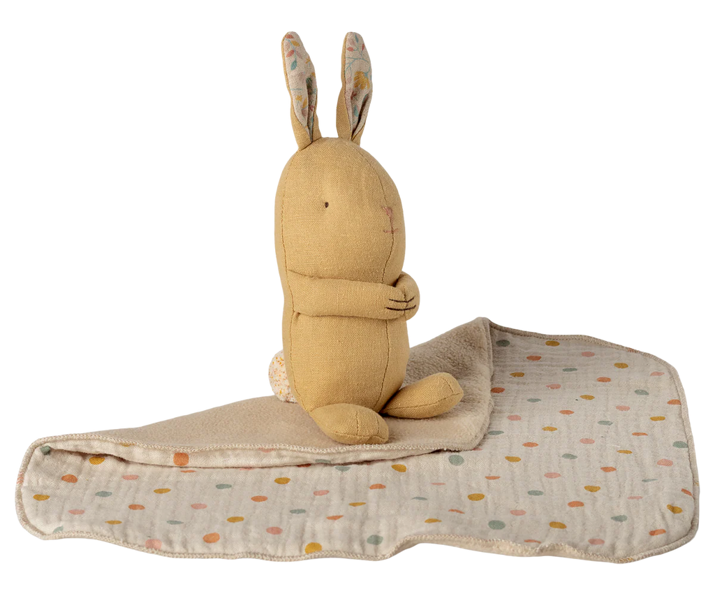 The Maileg Lullaby Friends Bunny Mini in cream yellow, with long polka-dotted ears, sits upright on a matching dotted blanket—an ideal newborn gift combining softness and cozy style. Expected arrival: 04/15/26.