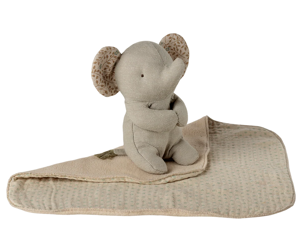 The Maileg Lullaby Friends, Elephant, Mini - Iron Grey sits on a folded beige textured baby blanket with patterned ears, creating a charming newborn gift.