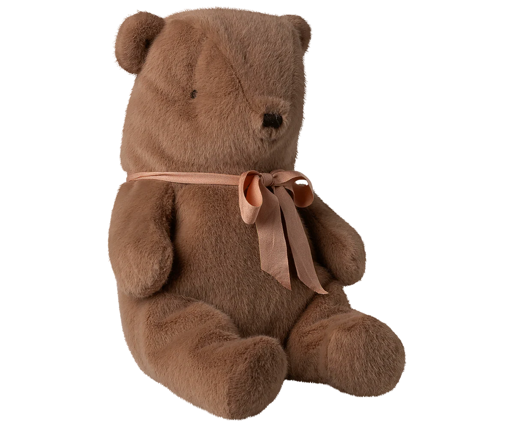 The Maileg Teddy Bear Plush, Medium – Soft Brown sits upright with a peach-colored ribbon around its neck and features a huggably soft texture, shown against a plain white background.