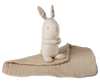 The Maileg Lullaby Friends Bunny, Mini - Nature is a beige stuffed rabbit with patterned ears, seated upright on a matching textured baby blanket—an adorable newborn gift.