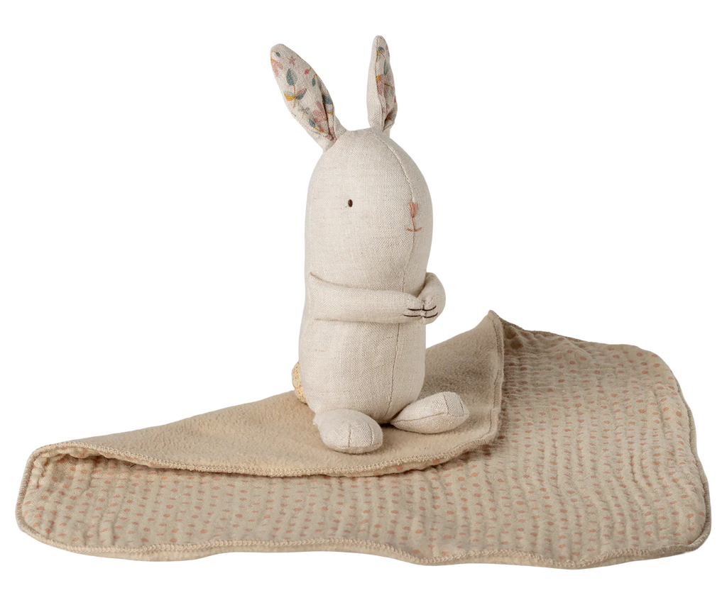 The Maileg Lullaby Friends Bunny, Mini - Nature is a beige stuffed rabbit with patterned ears, seated upright on a matching textured baby blanket—an adorable newborn gift.