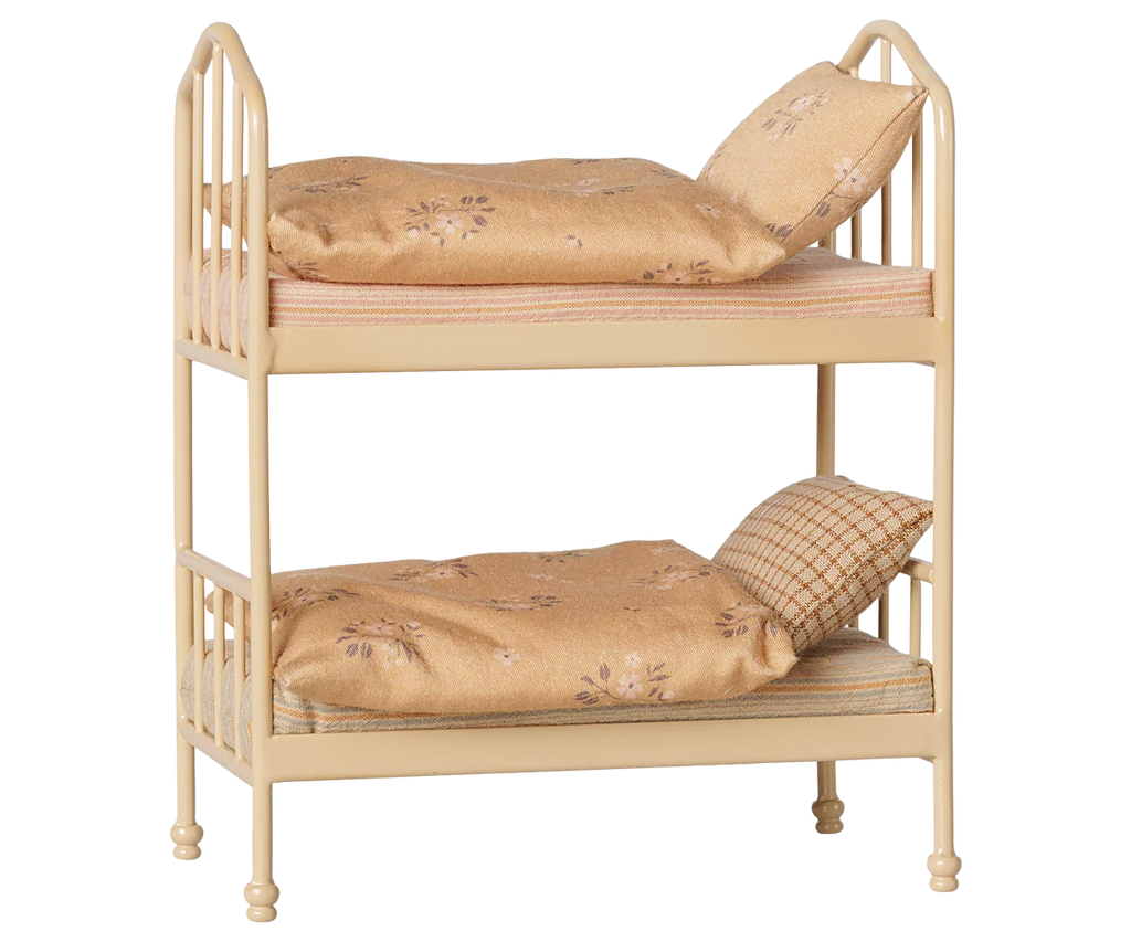 The PRE-ORDER: Maileg Bunk Bed, Mouse - Wheat features two levels with patterned bedding and pillows. With vertical rails, rounded ends, and subtle floral/plaid details, it's the perfect sleepover toy. Estimated arrival mid August.