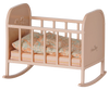 The PRE-ORDER: Maileg Cradle, My - Light Rose is a small beige rocking cradle with simple railings, including a pastel-patterned pillow and mattress. Estimated arrival is early September.