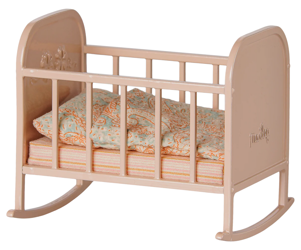 The PRE-ORDER: Maileg Cradle, My - Light Rose is a small beige rocking cradle with simple railings, including a pastel-patterned pillow and mattress. Estimated arrival is early September.