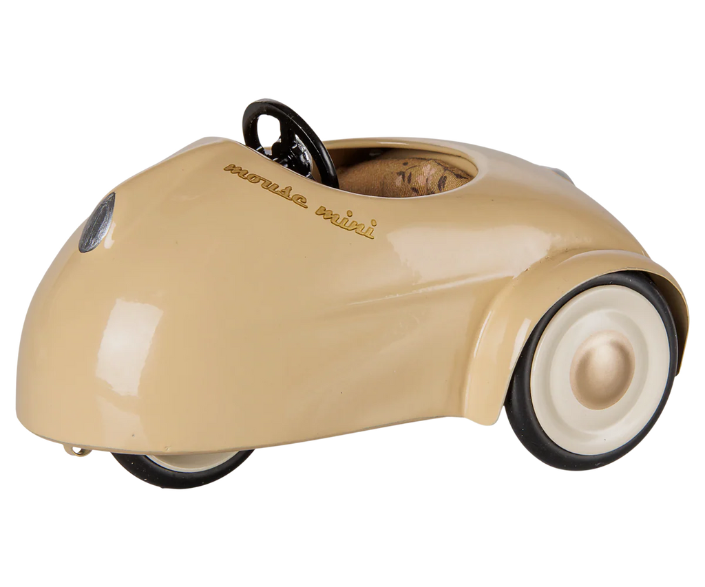 A small, beige ("Wheat") Maileg pull along toy car for mice with a rounded, minimalist design, white wheels, black tires, and a black steering wheel. PRE-ORDER: Maileg Car, Mouse - Wheat (Estimated Arrival Mid August).