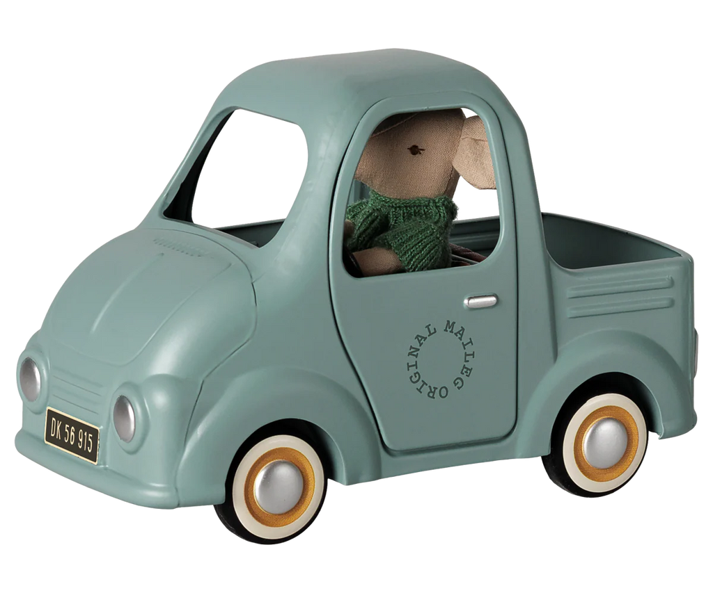 The PRE-ORDER: Maileg Truck, Mouse (Estimated Arrival Early November) is a pale blue toy pickup with gold-and-white wheels and a toy license plate. A stuffed mouse in a green sweater sits in the driver's seat—perfect for imaginative play.