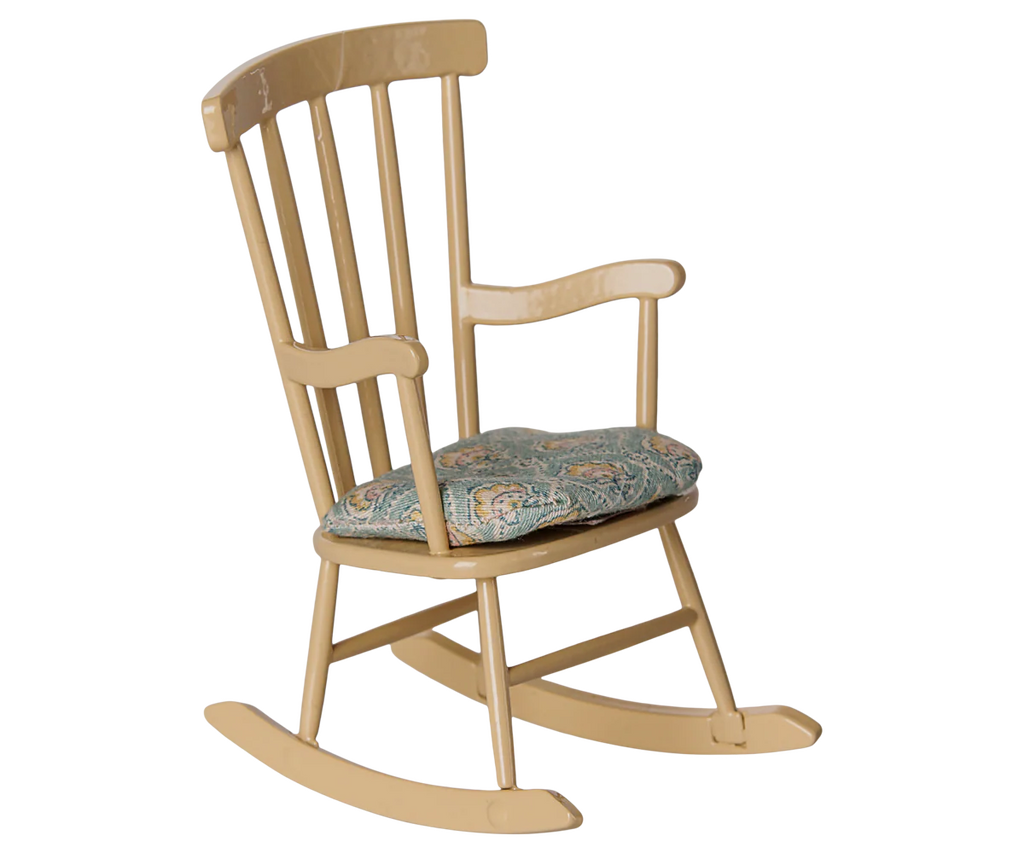 A beige PRE-ORDER: Rocking Chair, Mouse - Wheat with vertical slats and armrests features a cushioned seat. From Mouse hole Farmhouse, it is shown isolated on a white background. Estimated arrival mid August.