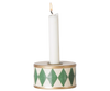 The PRE-ORDER Maileg Christmas Candle Holder, Drum - Green/Off White, features a lit white candle in a round holder with green diamond patterns and a gold rim, perfect for adding cosy Christmas decor. Estimated arrival: mid October.