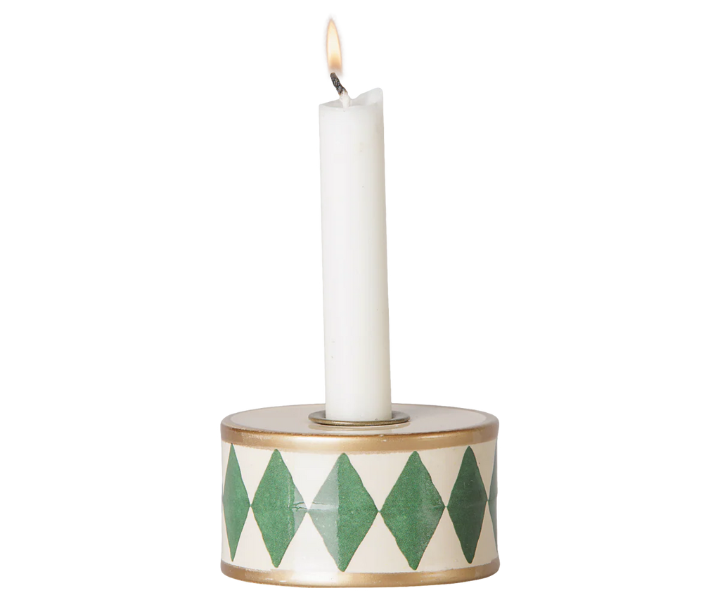 The PRE-ORDER Maileg Christmas Candle Holder, Drum - Green/Off White, features a lit white candle in a round holder with green diamond patterns and a gold rim, perfect for adding cosy Christmas decor. Estimated arrival: mid October.