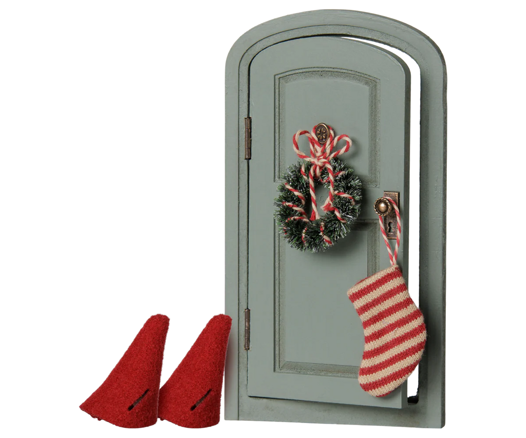 The PRE-ORDER: Maileg Christmas Door Set, Mouse (Estimated Arrival Early November) features a small green door with a wreath, candy canes, and a striped stocking, plus two red felt hats from the Christmas mice set placed in front.