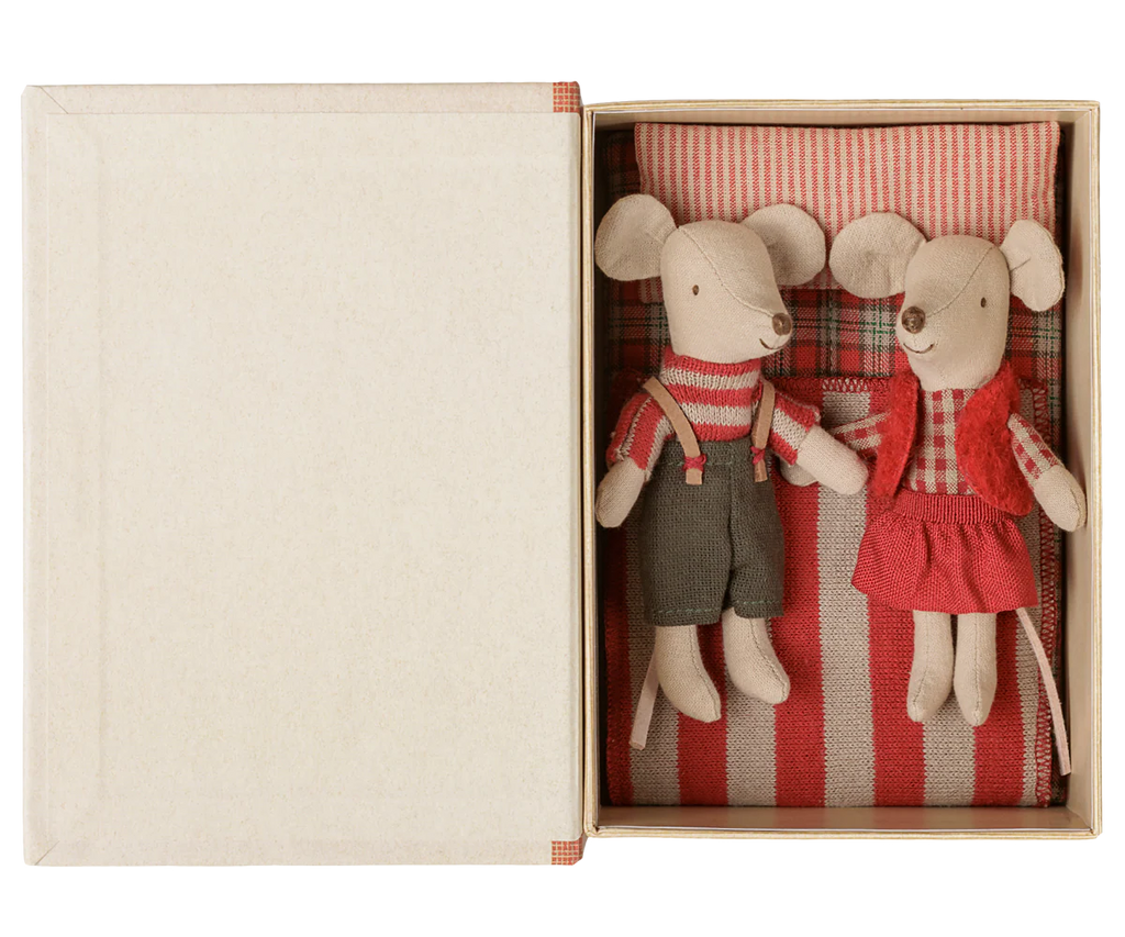PRE-ORDER: Maileg Christmas Twin Mice—Little Sister in a red skirt and vest, Brother in overalls—rest on a striped mattress with bedding inside an open box shaped like a small bed. Estimated arrival: Early September.