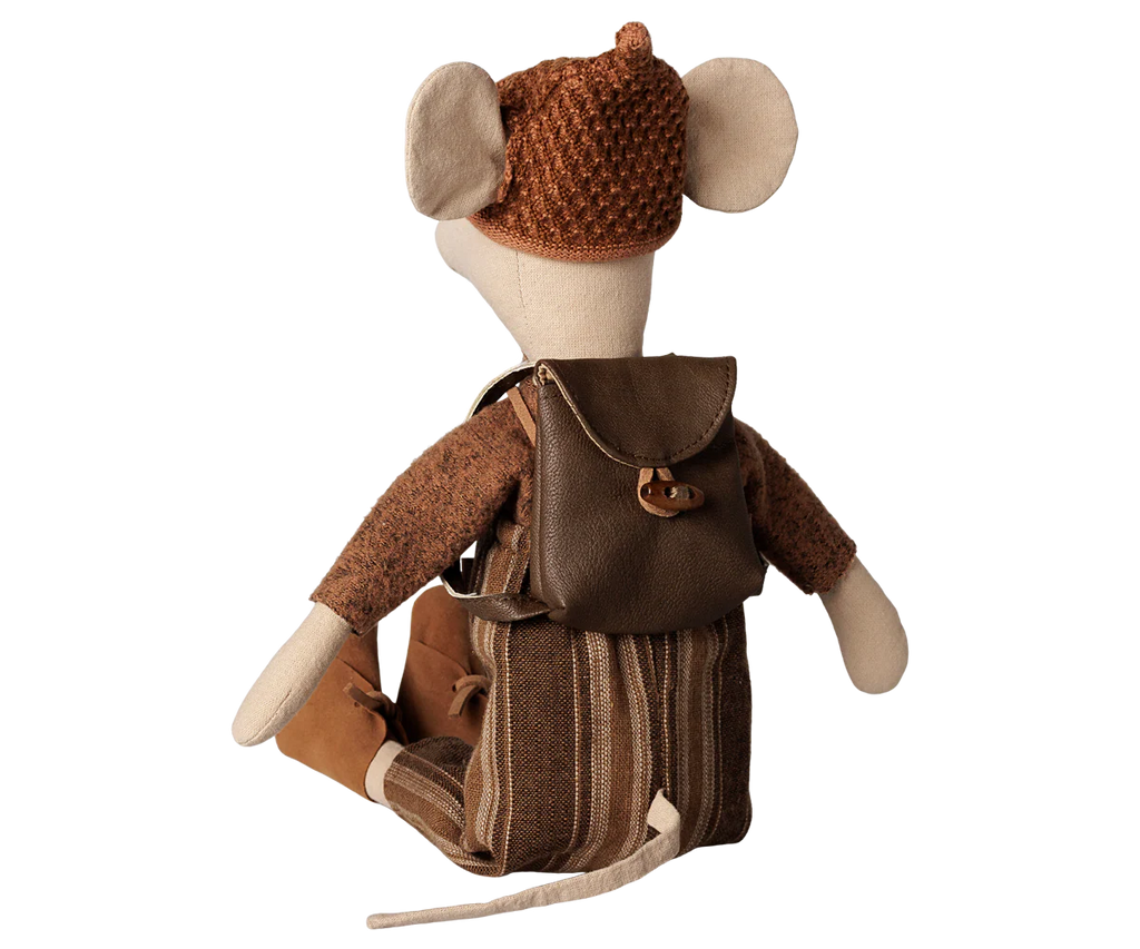 The PRE-ORDER: Maileg Backpack, Medium Mouse (arriving early November) features a vintage-style stuffed mouse in brown clothes and boots, wearing a knitted hat and striped backpack, seated with its back to the viewer on a plain background.