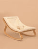 The Charlie Crane LEVO Baby Rocker features a sleek curved wooden frame and a soft 'Fur' cushion, shown against a plain beige background.