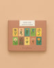 The "Memory Game - Festival of Flowers" is a boxed memory game with watercolor flower illustrations on the cover, set against a light brown background.