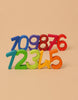 Grimm's Building Set - Numbers features rainbow numbers 1-9 in vibrant colors, upright in two staggered rows on beige. Perfect for building and stacking, it makes learning fun and helps develop motor skills.