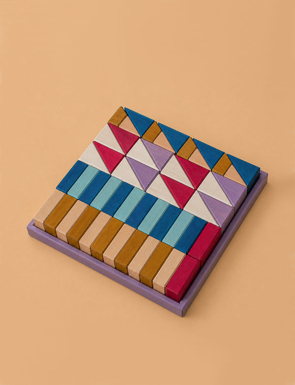 The Grimm's Small Building Block Set - Rhythm features wooden blocks in assorted shapes and vibrant colors, including triangles and rectangles, arranged in a square frame. Part of the TINY ART COLLECTION.