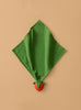 Sweetie the Strawberry Big Doudou, made of green organic cotton, is displayed diagonally on a beige background with a small red strawberry accent attached to one corner.