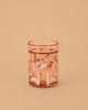 The Konges Sloejd Glitter Cup - Woof Letter Rose (Single) is a pink kids’ cup featuring playful dog, bone, and star designs, filled with water and set against a plain beige background.