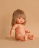 The Minikane Baby Doll (13") - Zoe sits on a beige surface against a matching background, featuring straight light brown hair, wide eyes, parted lips, chubby limbs, and lifelike details. Clothing sold separately.