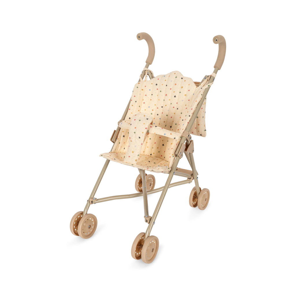 A beige, collapsible Konges Sloejd Doll Stroller - Multi Star with a polka dot fabric seat and backrest. The stroller has four pairs of brown double wheels and rounded beige handles, designed for children to play with.