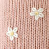 Close-up of Cuddle + Kind Daisy the Kitten's pink premium cotton knit, featuring two small white and yellow embroidered flowers.