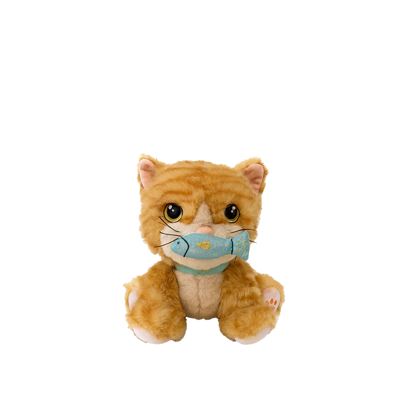The Olli Ella Dinkum Cat Binx - Ginger is a plush orange cat with big brown eyes, sitting upright and holding a blue fish toy in its magnetic mouth—perfect for imaginative play.