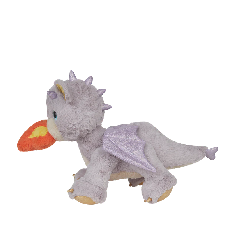 The Olli Ella Dinkum Dragon - Flare - Lavender is a posable gray plush dragon with purple wings and spikes, yellow feet, and an orange-red flame from its mouth, shown in side profile on a plain white background.