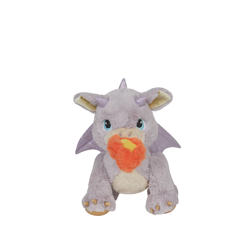 The Olli Ella Dinkum Dragon - Flare - Lavender is a plush lavender dragon with blue eyes, small wings, and orange-yellow flame-like fabric from its mouth, shown sitting against a plain white background.
