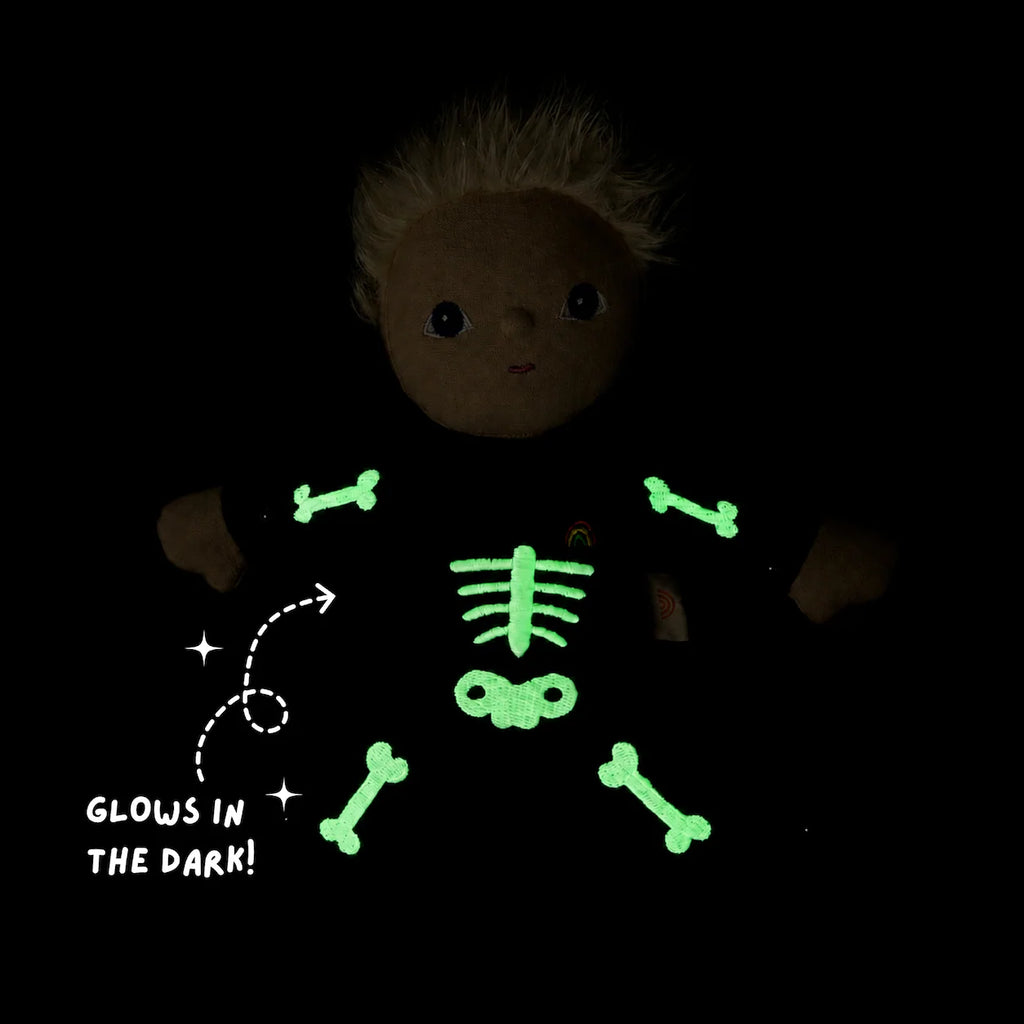 Olli Ella Dinky Dinkum Doll - Scully Skeleton plush wearing a black onesie with a glow-in-the-dark skeleton print and text that reads “Glows in the dark!”.
