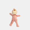 The Olli Ella Dozy Dinkum - Moppet is a soft cotton baby doll with closed eyes, wearing a pink onesie and matching hood, standing with arms slightly spread against a plain light gray background.