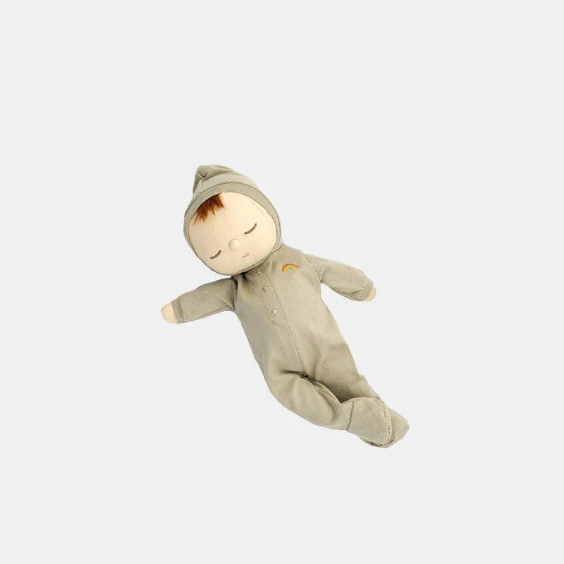 The Olli Ella Dozy Dinkum - Pickle is a soft cotton doll in a light green hooded onesie with a rainbow patch, lying on its side with closed eyes and a peaceful expression—an ideal first toy for babies.