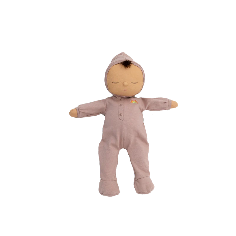 Olli Ella Dozy Dinkum - Pip is a soft cotton doll with closed eyes, light brown skin, and a brown tuft of hair, dressed in a pink rainbow hooded onesie—perfect as baby’s first toy. Pictured arms outstretched on a plain white background.