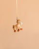 The Bukowski - Pony Sugar Bag Charm, a small plush horse toy designed as an adorable pony accessory, hangs by a yellow strap against a plain beige background.