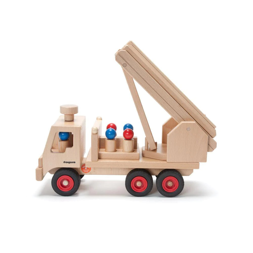 A Fagus wooden fire truck with a movable crane, equipped with red wheels and loaded with firefighter peg figures, isolated on a white background.