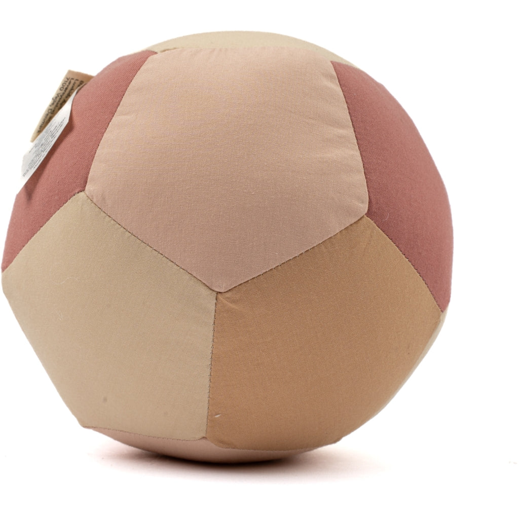 The Fabric Ball - Dusty Rose is a soft organic cotton baby toy with pentagonal panels in beige, tan, and dusky pink tones and a small fabric tag attached. Ideal as a gentle developmental toy for infants.
