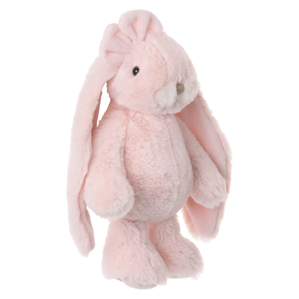 Standing upright against a white background, the Bukowski - Friendly Kanina - Misty Rose is a soft, light pink plush bunny with long floppy ears, a round belly, and a small beige nose—a comforting stuffed animal that brings warmth and joy to any setting.