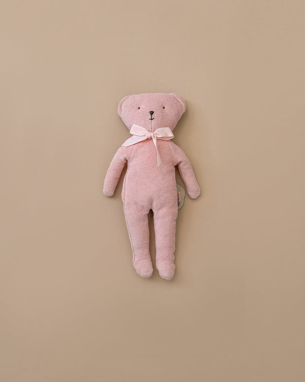 The Maileg Teddy - Rose, a cuddly pink teddy bear with soft fabric and a bow around its neck, is positioned upright against a plain beige background.