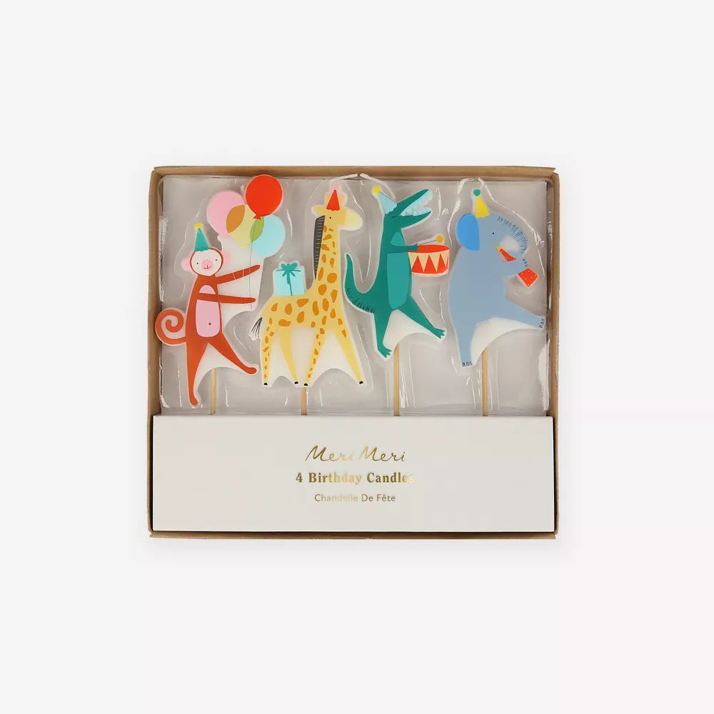 A box of four Meri Meri Animal Parade Candles shaped like a monkey, giraffe, dinosaur, and horse, each decorated with vibrant colors and playful designs.