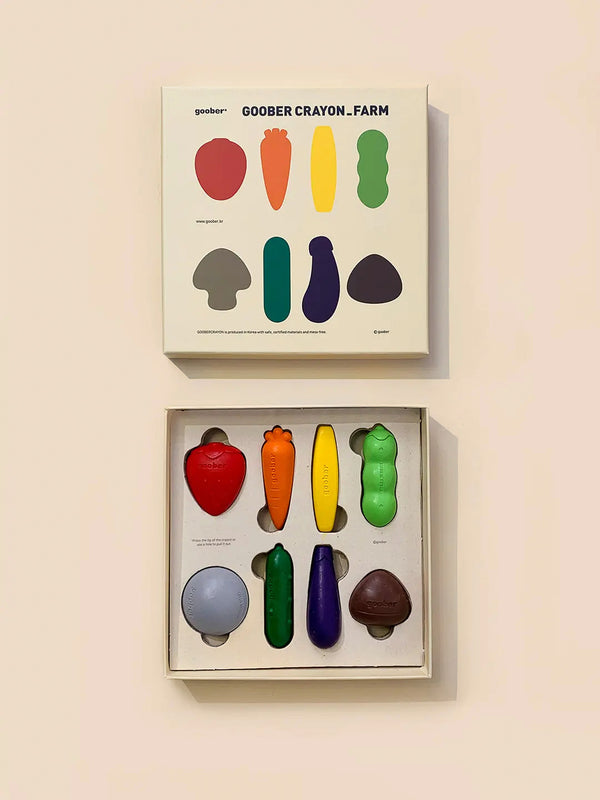 A box of Farm Crayons shaped like farm vegetables, displayed next to its packaging which features color-matching illustrations.